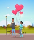 Man giving woman pink heart shape air balloons happy valentines day concept african american couple in love over city Royalty Free Stock Photo