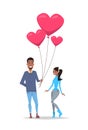 Man giving woman pink heart shape air balloons happy valentines day holiday concept african american couple in love full