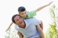 Man giving young boy piggyback ride smiling