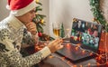 Man with a glass of champagne is remotely communicating with friends and family via video link. Concept of party online