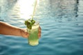 Man with glass of fresh summer cocktail near pool outdoors, closeup. Space for text Royalty Free Stock Photo