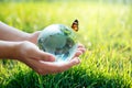 A man with a glass globe Concept day earth Save the world save environment The world is in the grass of the green bokeh background Royalty Free Stock Photo