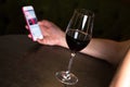 Man with glass of red wine looking at smartphone Royalty Free Stock Photo