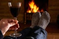 Man With Glass Of Red Wine Relaxing By Fire