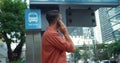 Man glasses answers call bus stop. convenience mobile connectivity daily life, answering calls anywhere. ubiquity