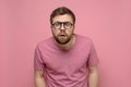 Man with glasses is confused, he leaned forward, looks with a shocked expression on his face and does not believe what Royalty Free Stock Photo