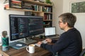 Developer working on code at a desk with multiple monitors and a laptop Royalty Free Stock Photo