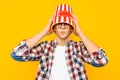 Man in glasses is happy to watch a movie, with a bucket of popcorn on his head, on a yellow background Royalty Free Stock Photo