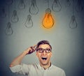 Man in glasses looking up at light bulb has solution Royalty Free Stock Photo