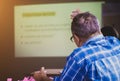 A man with glasses participates in a business seminar