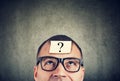 Man in glasses with question mark looking up Royalty Free Stock Photo