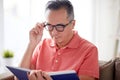 Man in glasses reading book at home Royalty Free Stock Photo