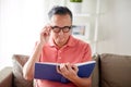 Man in glasses reading book at home Royalty Free Stock Photo