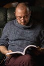 A man with glasses is reading a book. Middle-aged man of ordinary appearance in casual clothes at home. Reading, learning Royalty Free Stock Photo