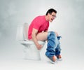 Man with glasses straining on the toilet.