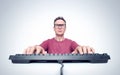 Man with glasses is typing on a keyboard while sitting in front of a computer. Royalty Free Stock Photo