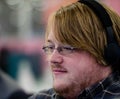 A man with glasses wearing headphones focussing in front of him Royalty Free Stock Photo