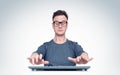 Man in glasses working at the computer, his hands hover over the keyboard while typing. Front view.