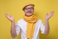 Man in glasses and yellow beret and scarf spreading hands up welcoming friend Royalty Free Stock Photo