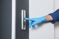 Man in glove pressing elevator call button, closeup. Protective measure Royalty Free Stock Photo