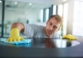 Man with gloves cleaning surface in office, health and hygiene in workplace, janitor at clean desk. Professional cleaner Royalty Free Stock Photo