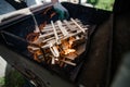 A man in gloves kindles fire from stacked wood. Preparation for a barbecue Royalty Free Stock Photo