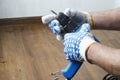 Man in gloves preparing a screwdriver for repair works at home.Closeup shot with empty space