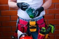 Man in gloves with a respirator against the background of a red brick wall with a full bag for tools.Concept safety workplace DIY