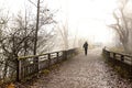 The man goes along the bridge in the fog to the car Royalty Free Stock Photo