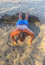 A man goes in for sports, does exercises on the seashore