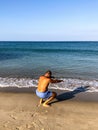 A man goes in for sports, does exercises on the seashore