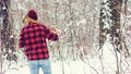 Man goes to the forest for a Christmas tree. Back view of lumberjack holding an ax on his shoulder. Save forest and keep green