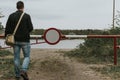 Man going into the barrier with a no entry sign . Road leads to the river Royalty Free Stock Photo