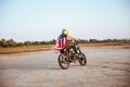 Man in golden helmet and american flag cape driving motorcycle Royalty Free Stock Photo
