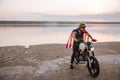 Man in golden helmet and american flag cape driving motorcycle Royalty Free Stock Photo