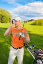 Man golfer watching into rangefinder