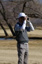 Man Golfing Using Rangefinder