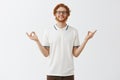 Man is good expample of patience and relaxation. Happy calm good-looking redhead guy with beard in glasses and white Royalty Free Stock Photo