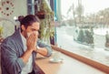 Man got nose allergy, flu sneezing nose sitting at the table in a trendy cafe