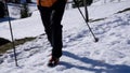 Man with GrÃ¶deln on mountain boots trudges up the snow-covered mountain with hiking sticks