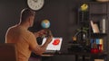 A man graphic designer holds plastic 3d printed model of human mandible. A sketch of heart in red colour on a laptop