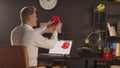 A man graphic designer sideways holds and views plastic 3d printed model of human heart. A sketch of organ in red colour