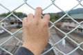 Man grasp the bar of cage with the defocus of city background