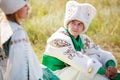 Man on grass in traditional clothes looks at his beloved woman