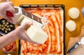 Man grating cheese on pizza base