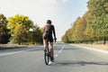 Man on a gravel bike on the road, back view.