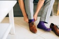 The man in gray slacks and a purple dress socks brown shoes with