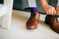 The man in gray slacks and a purple dress socks brown shoes with