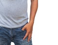 man in a gray T shirt and denims holds his hands in pockets on whitebackground