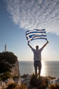 man with greece flag looking at sunset above the sea Royalty Free Stock Photo